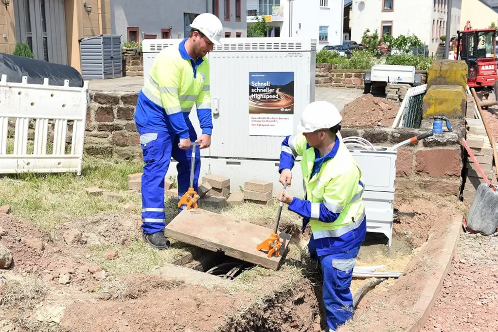 Foto: Zwei Mitarbeitende von Westconnect führen Straßenbauarbeiten für Glasfasernetze durch.