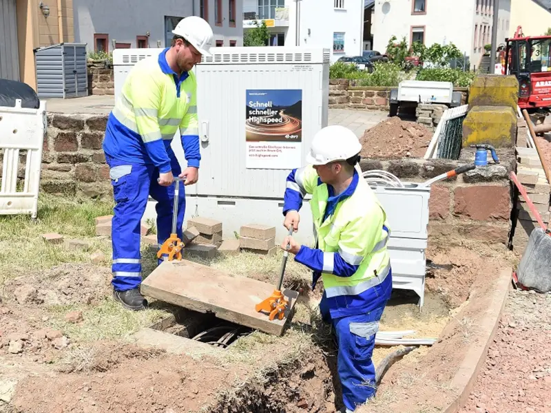 Foto: Zwei Mitarbeitende von Westconnect führen Straßenbauarbeiten für Glasfasernetze durch.