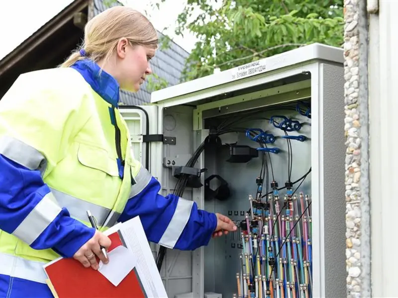 Foto: Eine Mitarbeiterin von Westconnect arbeitet an einem offenen Stromkasten.