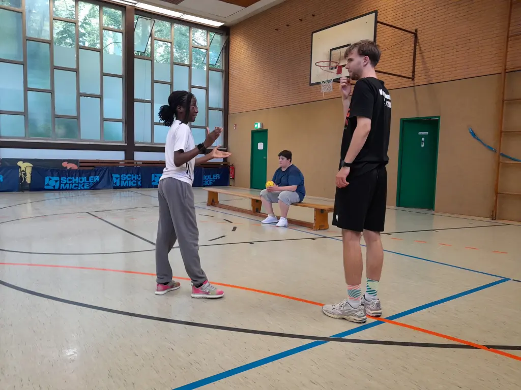 Bild: Der Trainer gibt einer Sch&uuml;lerin eine Trainingsanweisung.