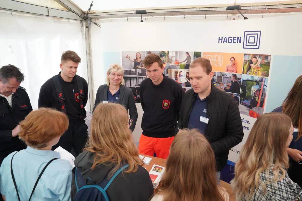 Foto: Mitarbeitende der Stadt Hagen erzählen bei der Ausbildungsmesse einer Gruppe von Teenagern von ihrer Arbeit.