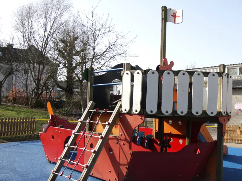 Ein Piratenboot auf einem Kinderspielplatz auf blauem Untergrund.