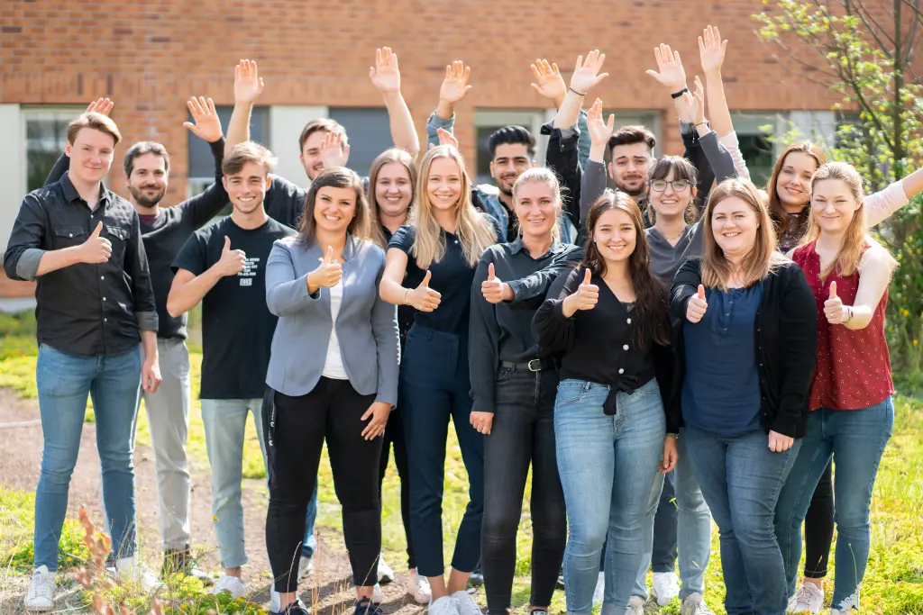 Foto: Ausbildungskr&auml;fte heben die Arme in den Himmel