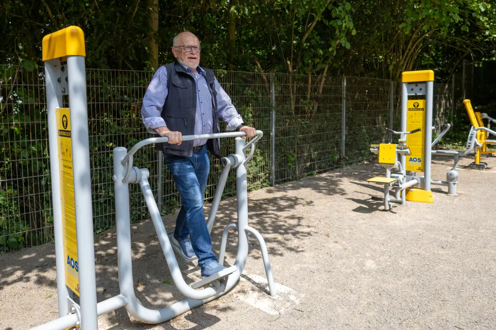 Foto: Bürgermeister Thieser auf einem neuen Sportgerät im Stadtgarten.
