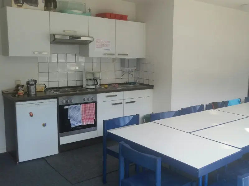 Foto: Eine Küchenzeile mit einer langen Tafel im Vordergrund.