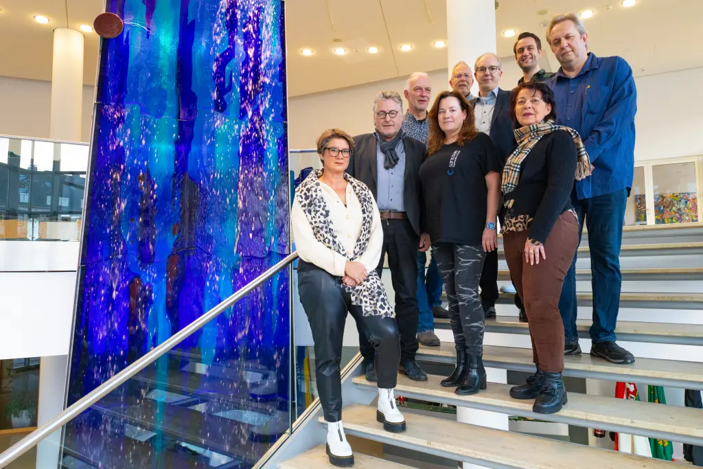 Foto: Die Mitglieder des ABB stehen auf der Treppe im Foyer des Rathaus an der Volme, im Hintergrund ist der Wasserverlauf.