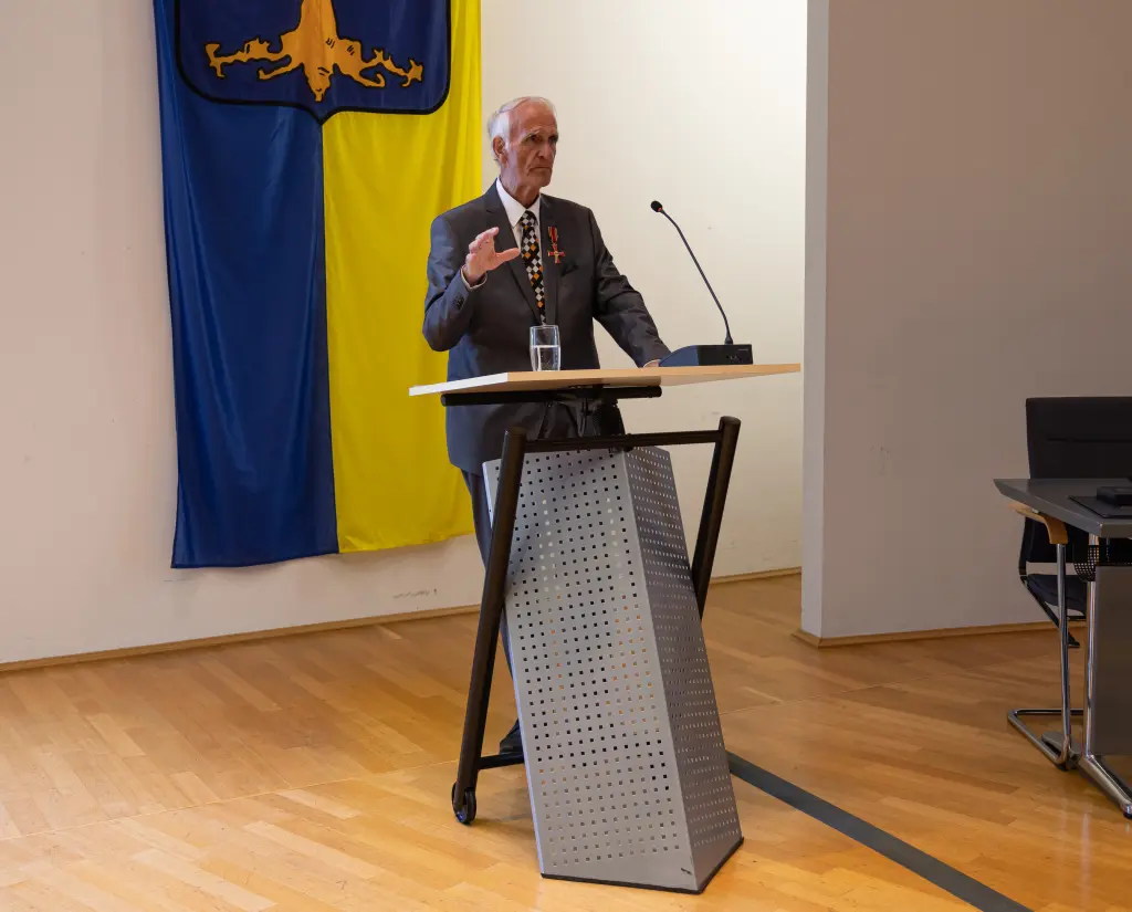 Foto: Der Bürgermeister Hans-Dieter Fischer am Podium im Rat der Stadt Hagen, im Hintergrund ist das Hagener Stadtwappen.