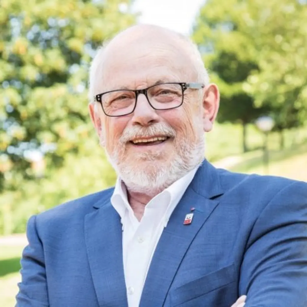 Foto: Dietmar Thieser schaut in die Kamera, im Hintergrund ist eine grüne Landschaft.