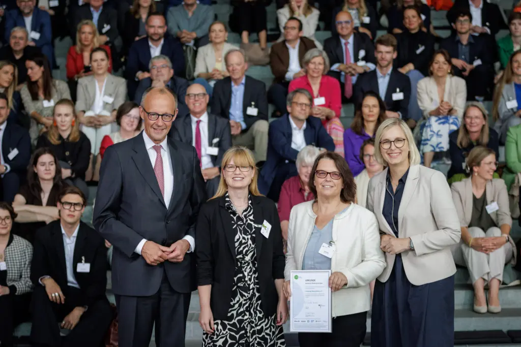 Bundeskanzler Friedrich Merz, Schirmherr von startsocial e.V., und Staatsministerin für Sport und Ehrenamt Dr. Christiane Schenderlein mit dem Bundespreisträger Irrsinnig Menschlich e.V., vertreten durch Caroline Lyle und Antje Wilde, auf der startsocial Preisverleihung am 9. Juni 2026 in Berlin