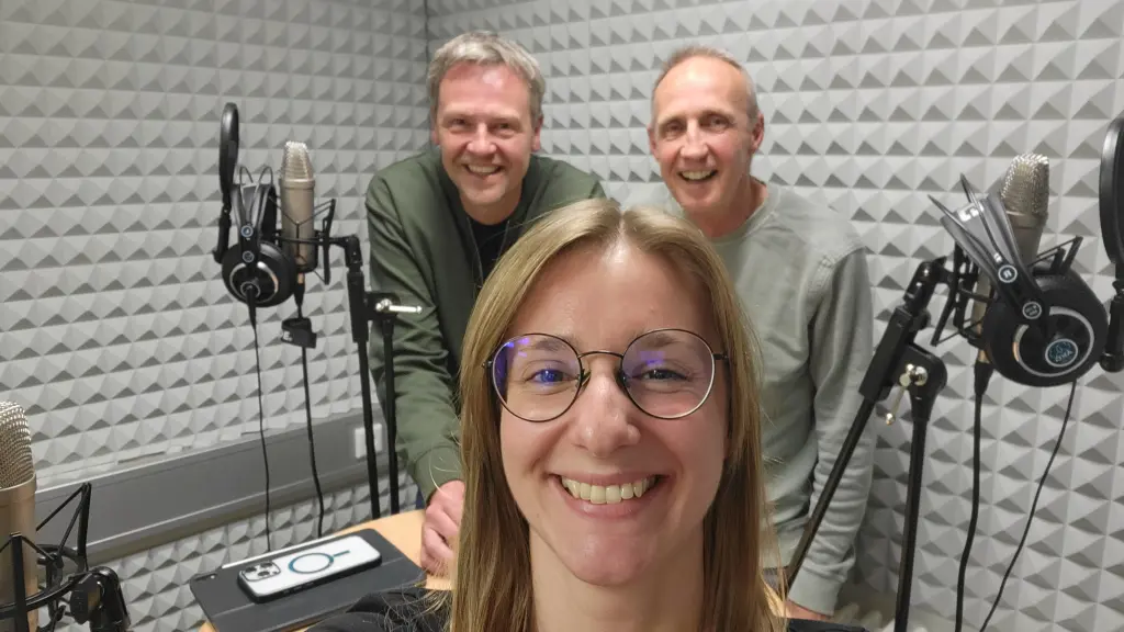 Drei Menschen stehen in einem Aufnahmestudio.