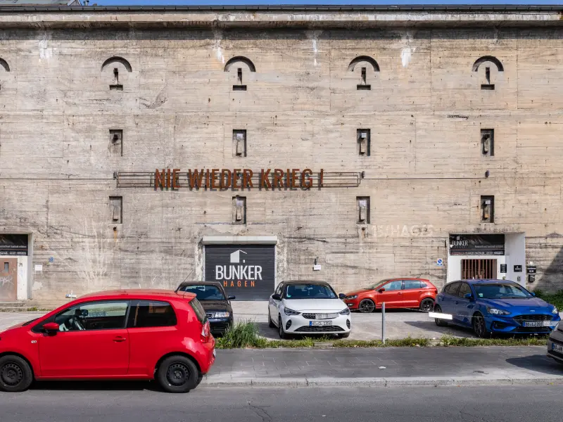 Foto des Bunker Mitte mit parkenden Autos im Vordergrund