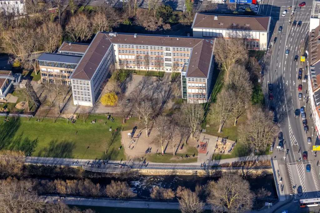 Foto: Luftfoto eines großen Schulgebäudes, angrenzend an einen Park uns einen Fluss.
