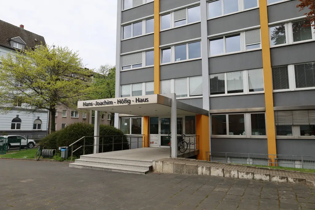 Foto: Ein großes älteres Betongebäude mit einer Treppe, die zur Eingangstür führt.