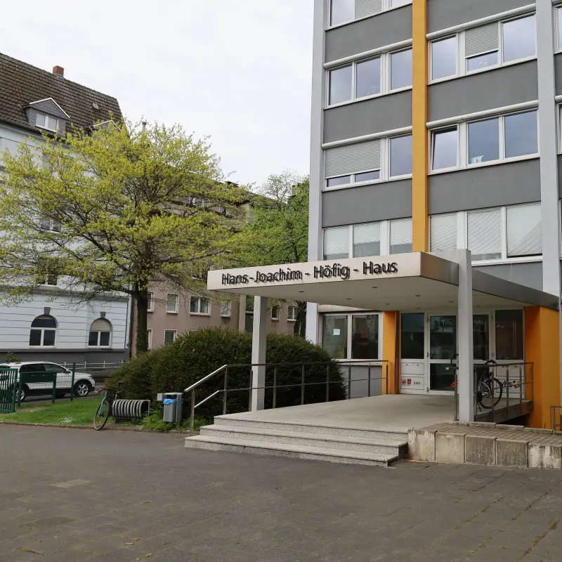 Foto: Ein großes älteres Betongebäude mit einer Treppe, die zur Eingangstür führt.