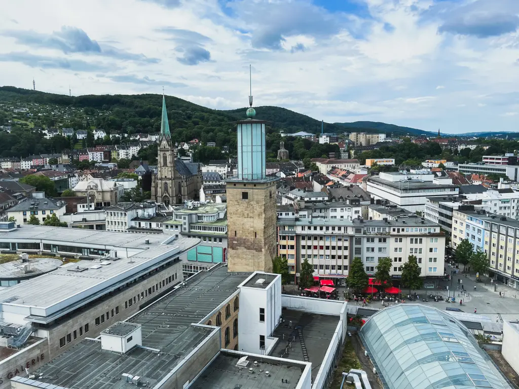 Foto: Luftbild einer Innenstadt mit einem Rathausturm.