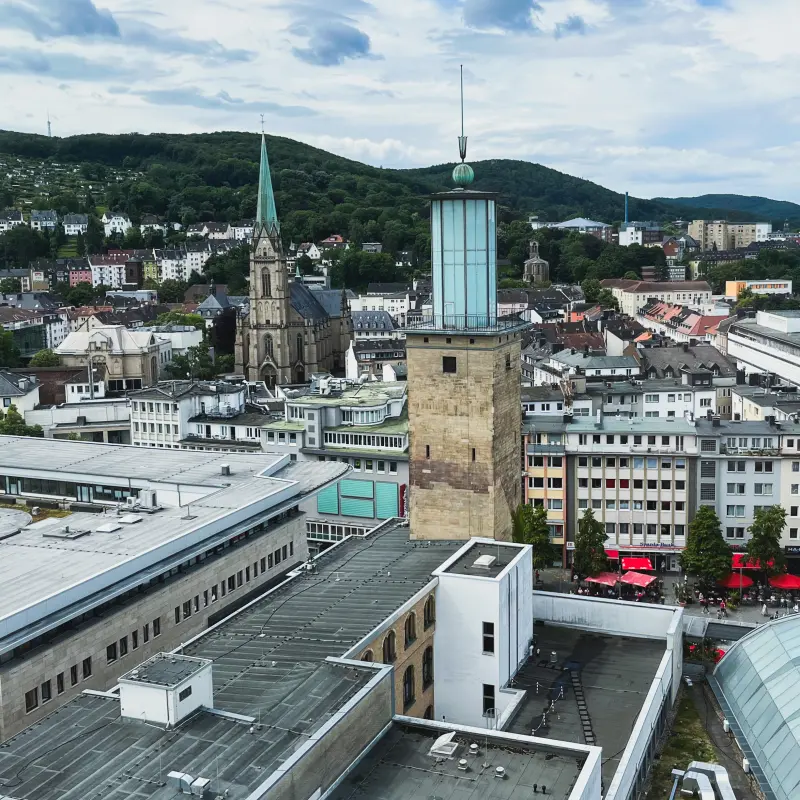 Foto: Luftbild einer Innenstadt mit einem Rathausturm.