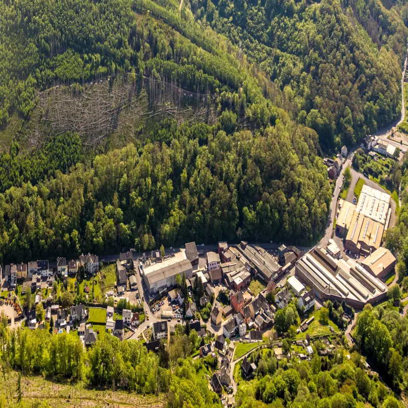 Foto: Das Luftbild einer Straße, die durch ein bewaldetes Tal führt.