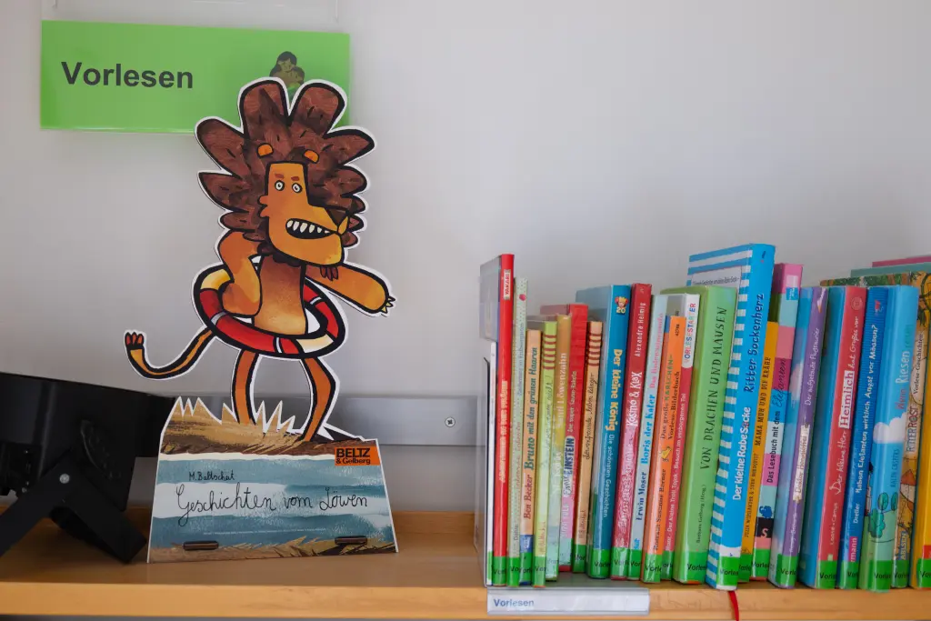 Foto: Rechts mehrere Bücher, links ein ausgedruckter Comic-Löwe.