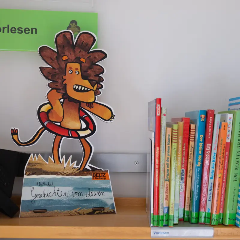Foto: Rechts mehrere Bücher, links ein ausgedruckter Comic-Löwe.
