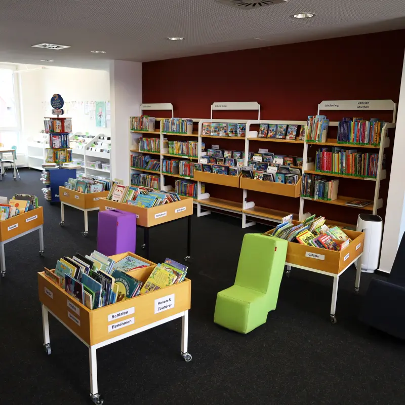 Eine Innenaufnahme der Stadtteilb&uuml;cherei. Zu sehen sind Sitzm&ouml;bel und B&uuml;cher.