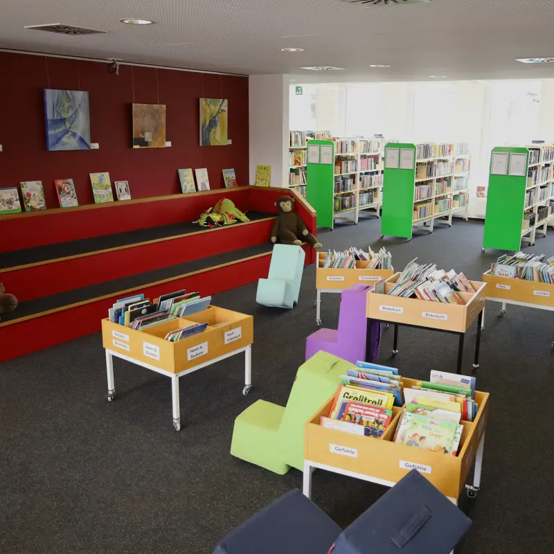 Foto: Innenansicht der Stadtteilb&uuml;cherei Haspe (Regale, B&uuml;chertische und eine Treppe zum Draufsetzen)