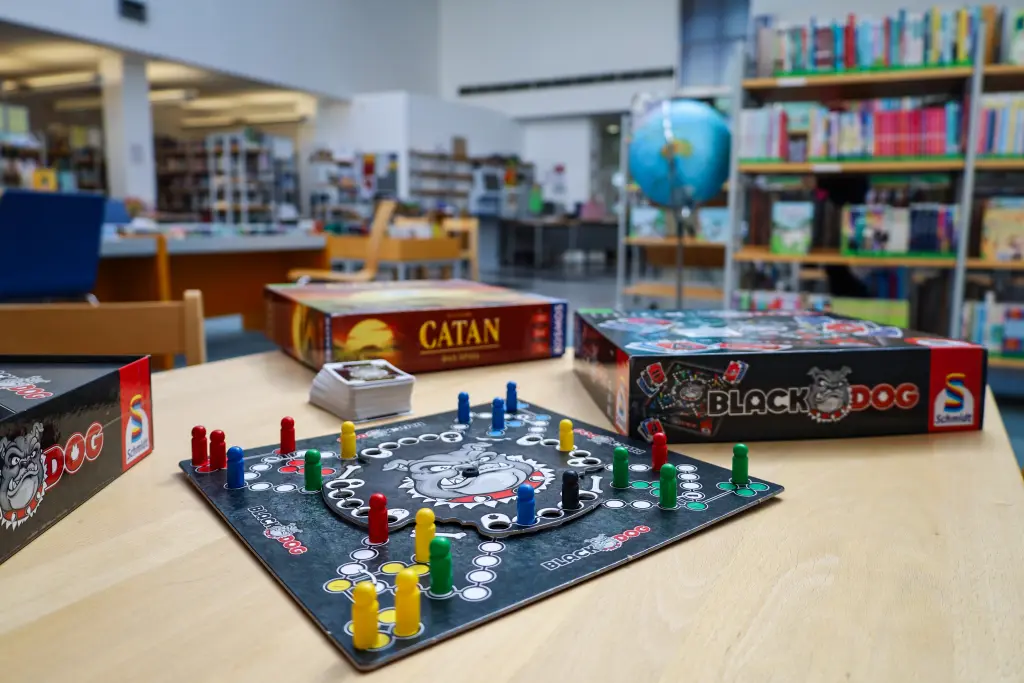 Foto: Ein Brettspiel liegt auf einem Tisch in einer Bücherei.