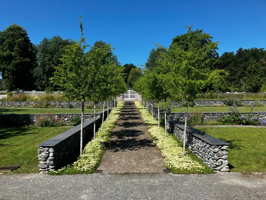 Der Garten der Villa Hohenhof mit Blick auf den wei&szlig;en Blumenzaun.