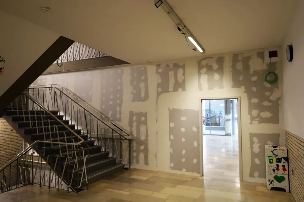 Foto: Ein Treppenhaus mit einem Türrahmen ohne Tür, der in den nächsten Raum führt.