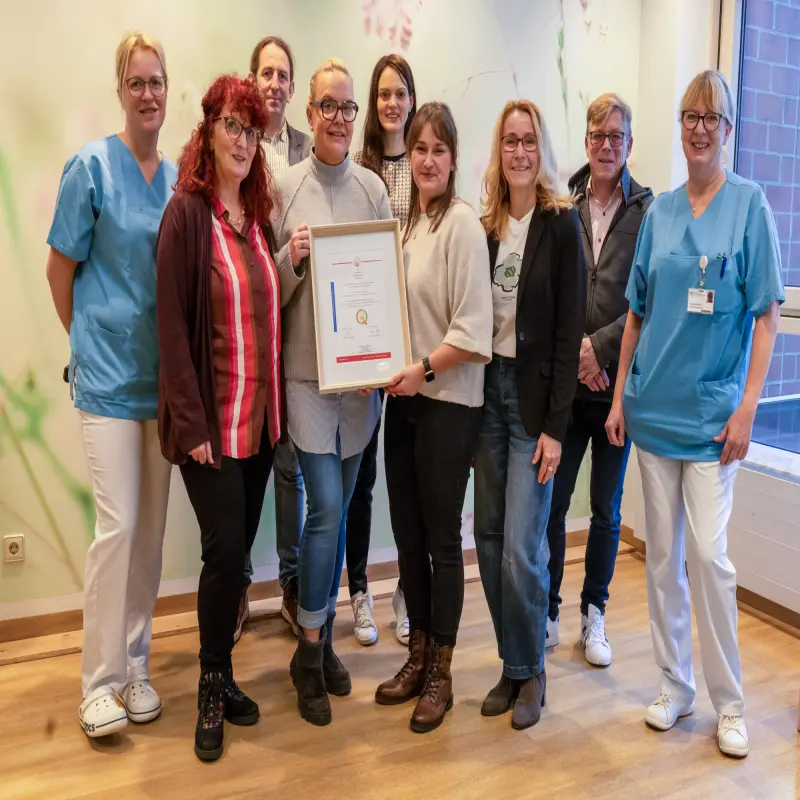 Foto: Mitarbeitende des Agaplesion Klinikums, der Caritas, der Stadt Hagen und der Evangelischen Jugendhilfe posieren mit dem bundesweiten Qualit&auml;tssiegel f&uuml;r die Babylotsen in Hagen.