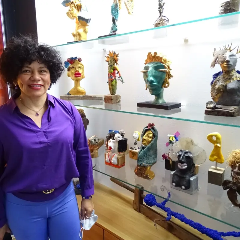 Foto: Eine Frau steht vor einer Vitrine mit Skulpturen.