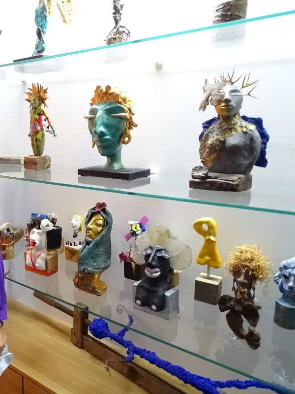 Foto: Eine Frau steht vor einer Vitrine mit Skulpturen.