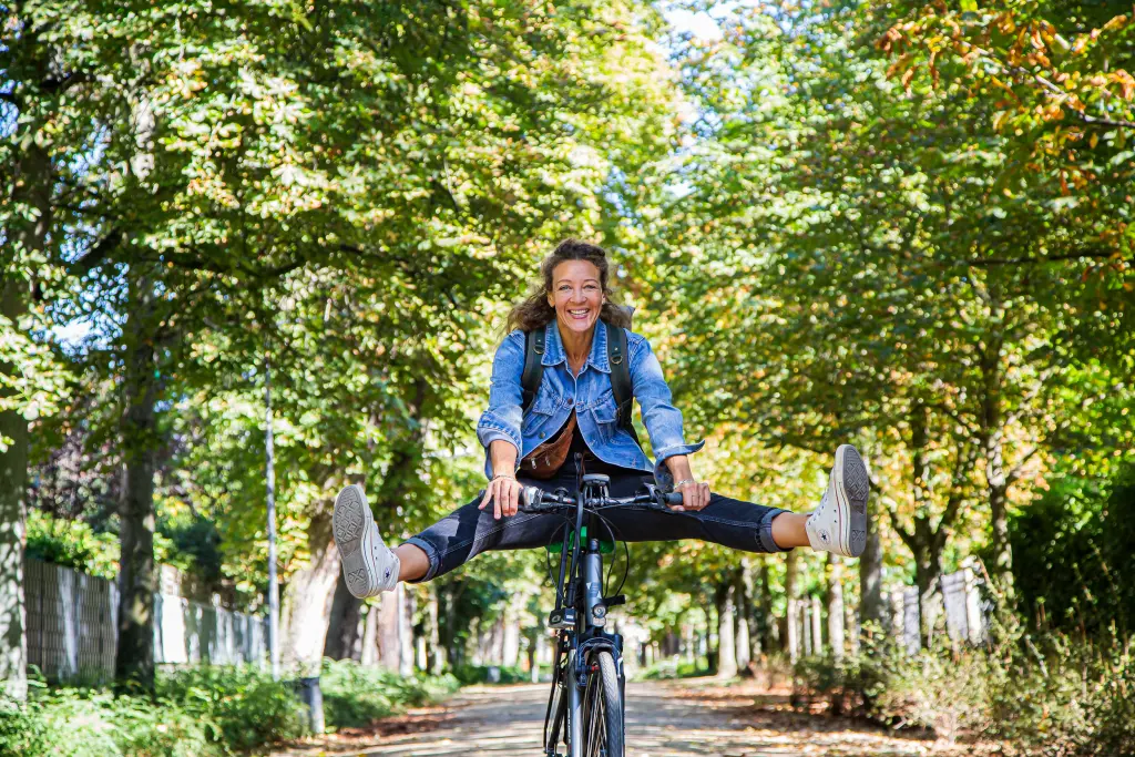 Foto: Eine Frau fährt auf einem Rad und streckt dabei ihre Beine aus.