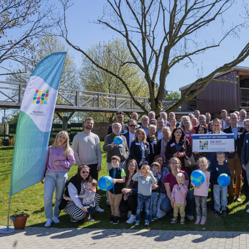 Foto: Ein Gruppenfoto vieler Menschen drau&szlig;en im Gr&uuml;nen.