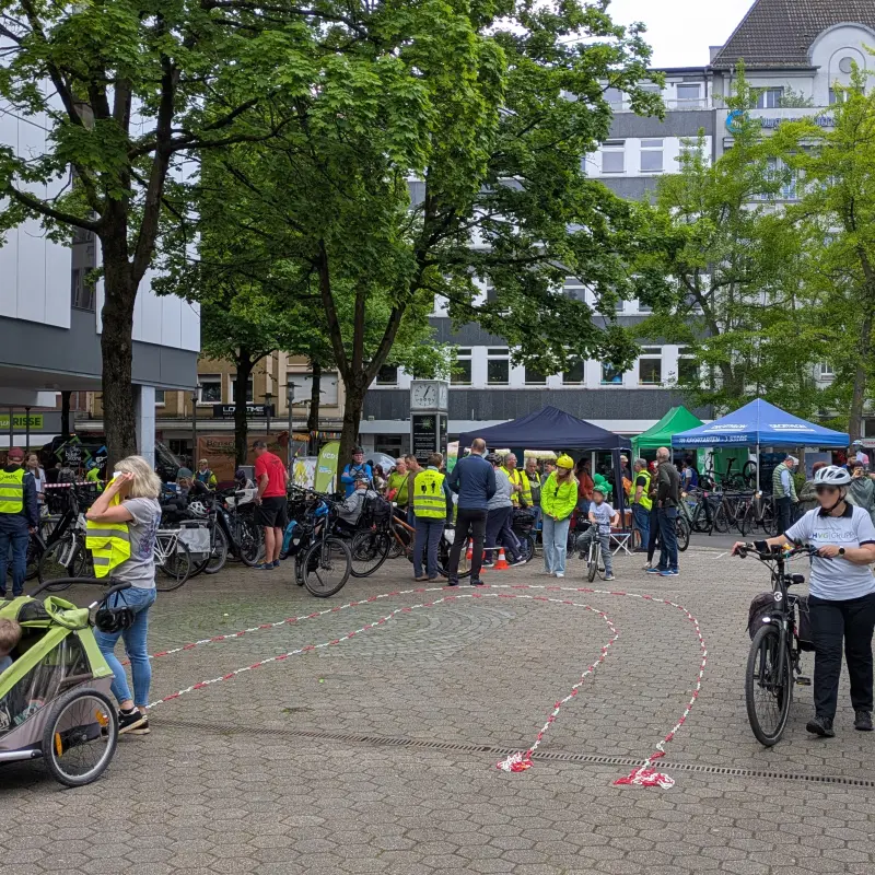 Foto: Viele Menschen - mit und ohne Fahrraf - tummeln sich in der Hagener Innenstadt. Einige haben gelbe Warnwesten an, auf dem Boden ist mir rot-wei&szlig;em Absperrband ein Fahrrafparcours aufgebaut worden.