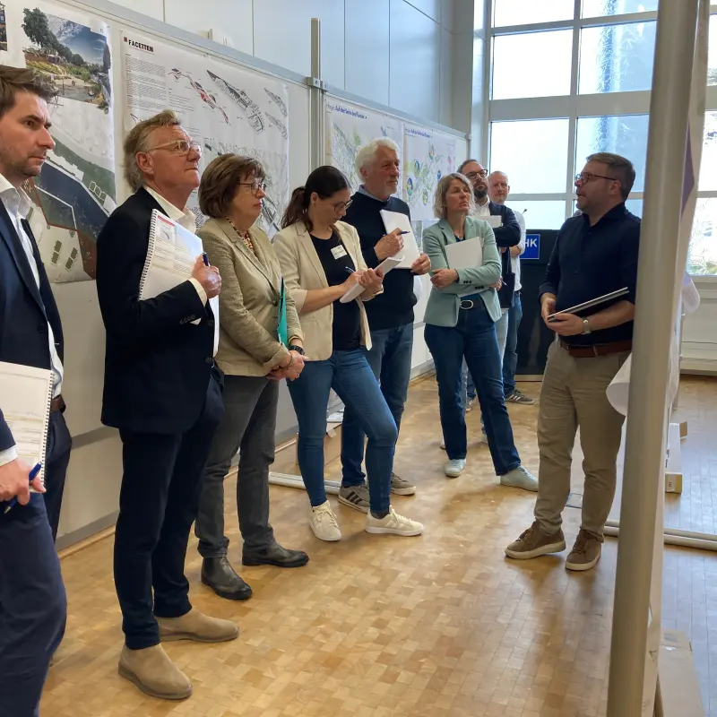 Foto: Viele Menschen stehen um Stellw&auml;nde mit Karten herum und haben Block und Stift in der Hand.