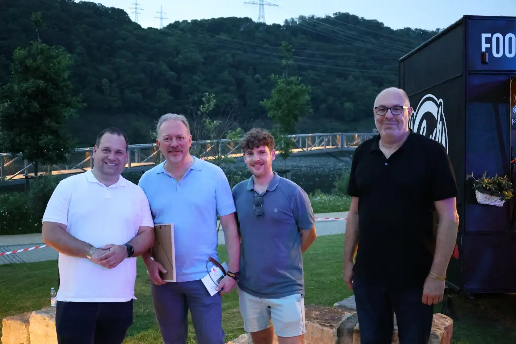 Foto: Ein Gruppenbild mit M&auml;nnern vor einem See.