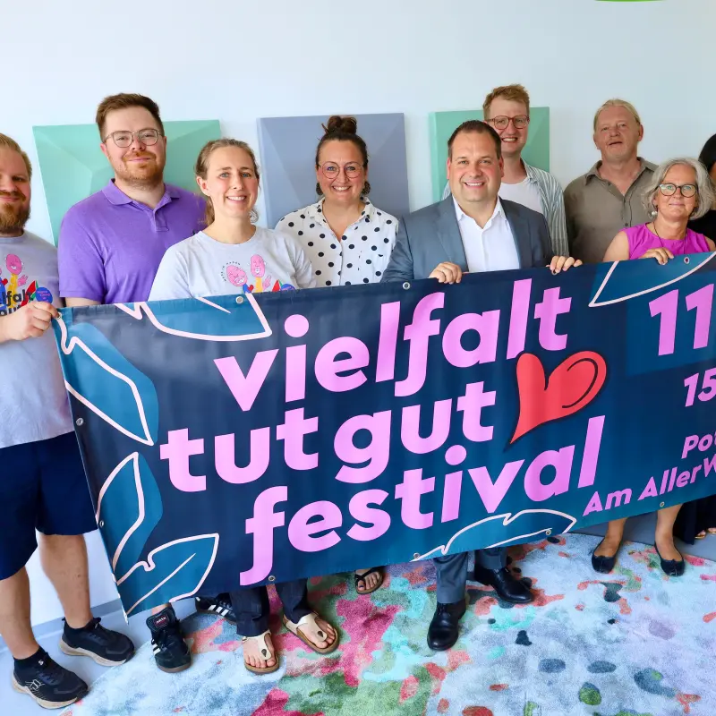 Foto: Die Mitwrikenden der Veranstaltergemeinschaft halten ein Banner mit Werbung f&uuml;r das "Vielfalt tut gut-Festival" in der Hand