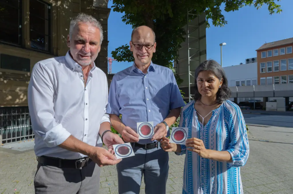 Foto: Die in der Bildzeile genannten Personen stehen nebeneinander und halten jeweils einen Hitze-Warn-Aufkleber in der Hand.
