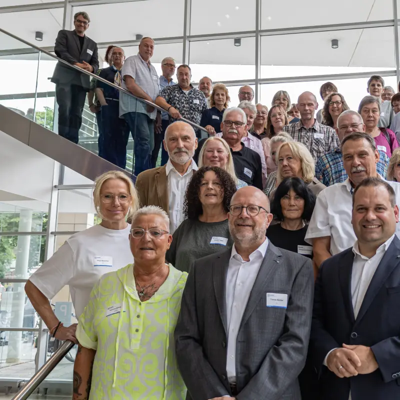 Foto: Oberb&uuml;rgmerister Dennis Rehbein steht zuammen mit den Pension&auml;rinnen und Pension&auml;ren auf der Treppe im Foyer des Rathauses an der Volme.