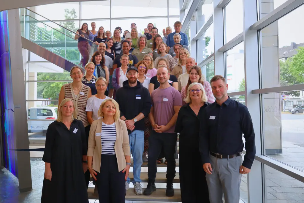 Foto: Die Teilnehmenden der Regionalplanungskonferenz stehen auf der Treppe im Foyer des Rathauses an der Volme.