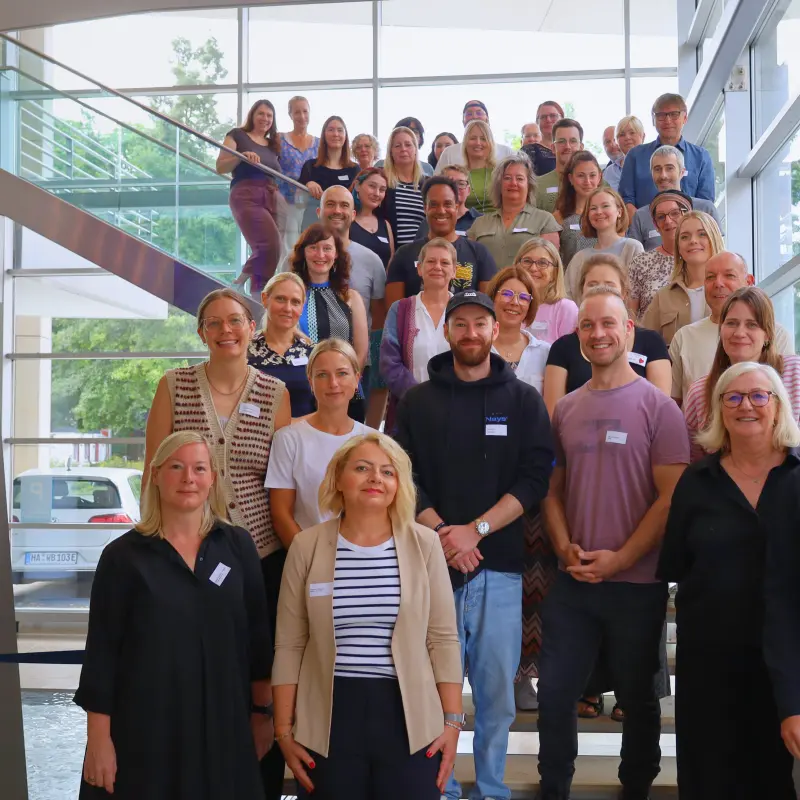Foto: Die Teilnehmenden der Regionalplanungskonferenz stehen auf der Treppe im Foyer des Rathauses an der Volme.