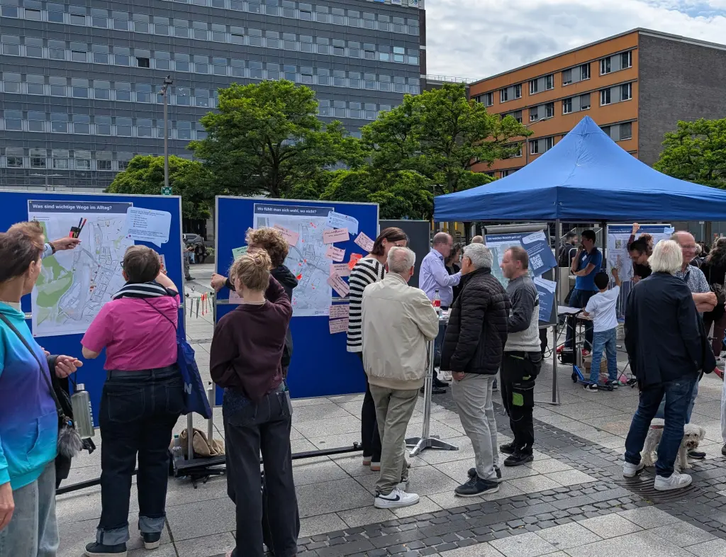 Fotos: Menschen stehen vor Stellw&auml;nden mit Karten und Zetteln.