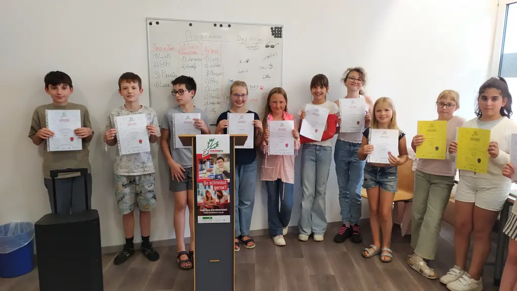 Foto: Die Kinder stehen aufgereiht nebeneinander und halten ihre Urkunde hoch.