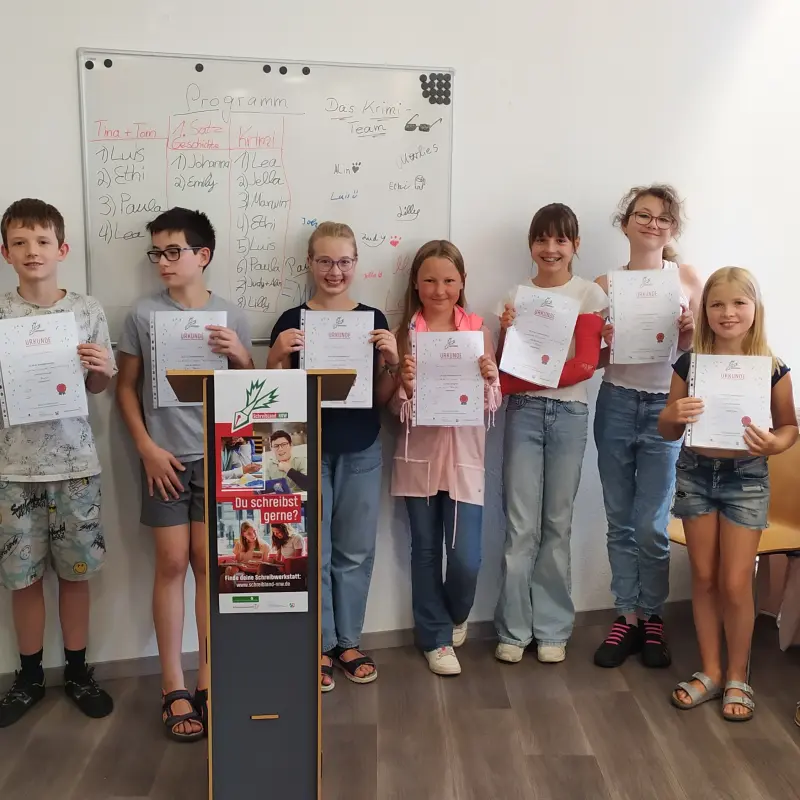 Foto: Die Kinder stehen aufgereiht nebeneinander und halten ihre Urkunde hoch.