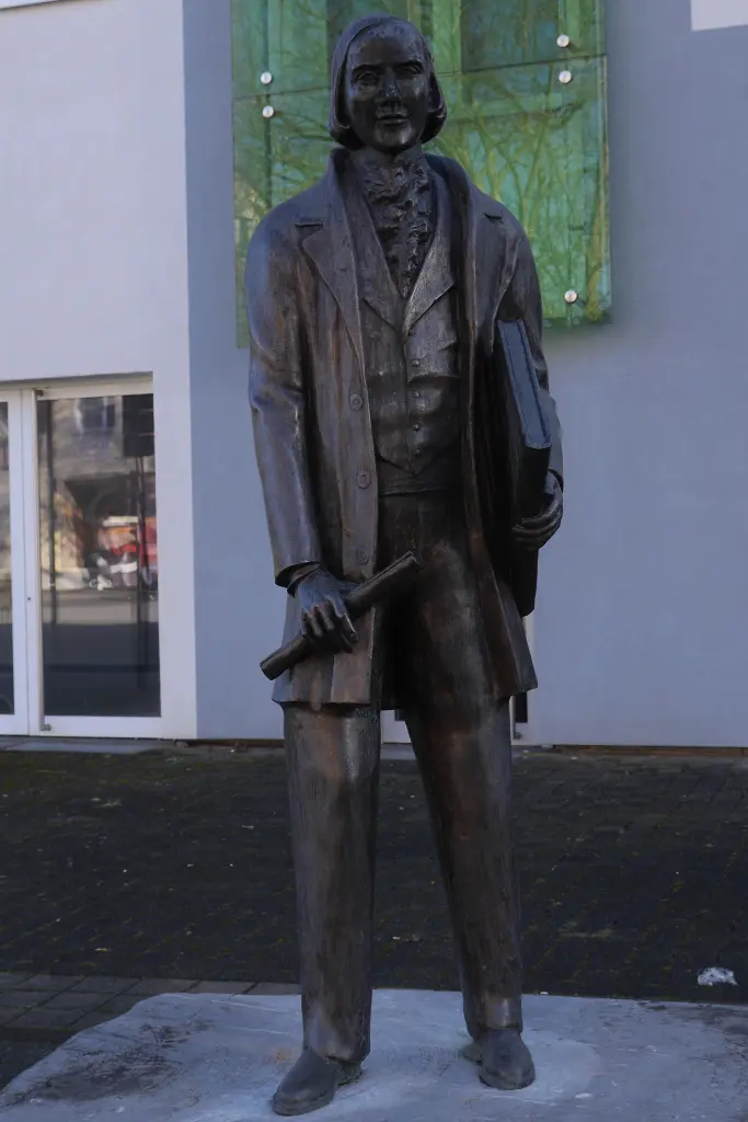 Foto: Ansicht Karl-Halle-Denkmal (Person mit einem Buch und einer Schriftrolle in der Hand)