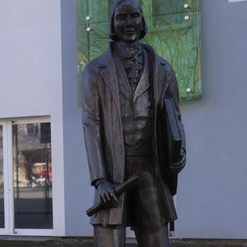 Foto: Ansicht Karl-Halle-Denkmal (Person mit einem Buch und einer Schriftrolle in der Hand)