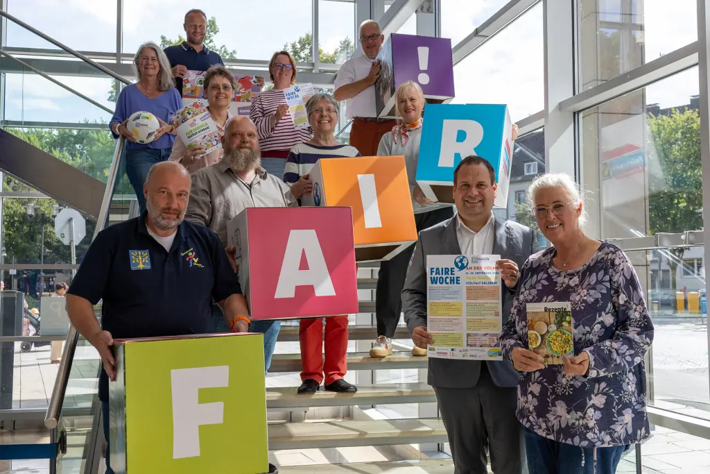 Foto: Mehrere Personen stehen auf einer Treppe und halten Würfel mit der Aufschrift "FAIR".