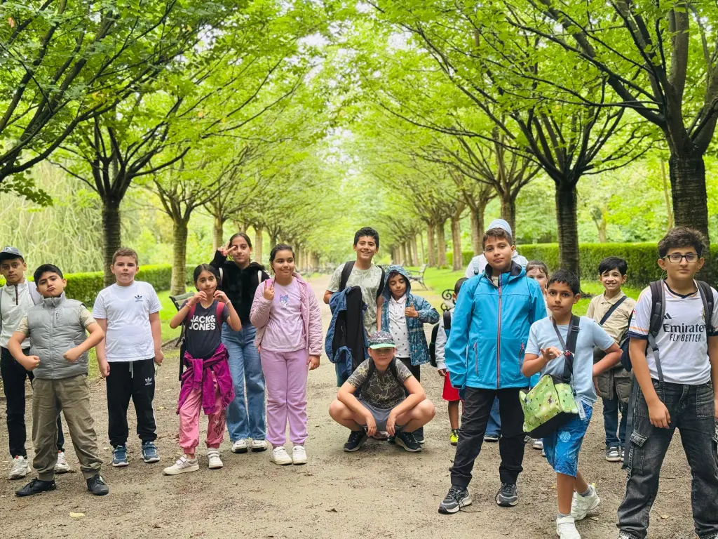Foto: Viele Kinder stehen auf einem Waldweg und posieren für die Kamera.
