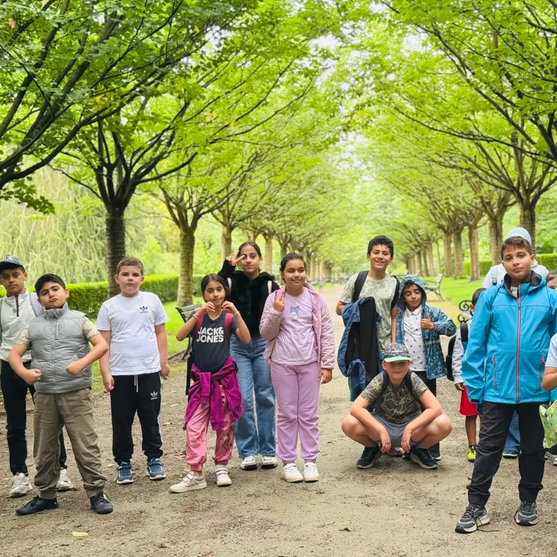 Foto: Viele Kinder stehen auf einem Waldweg und posieren für die Kamera.