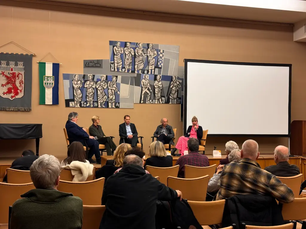 Foto: Zu sehen ist eine Podiumsdiskussion mit fünf Teilnehmenden.